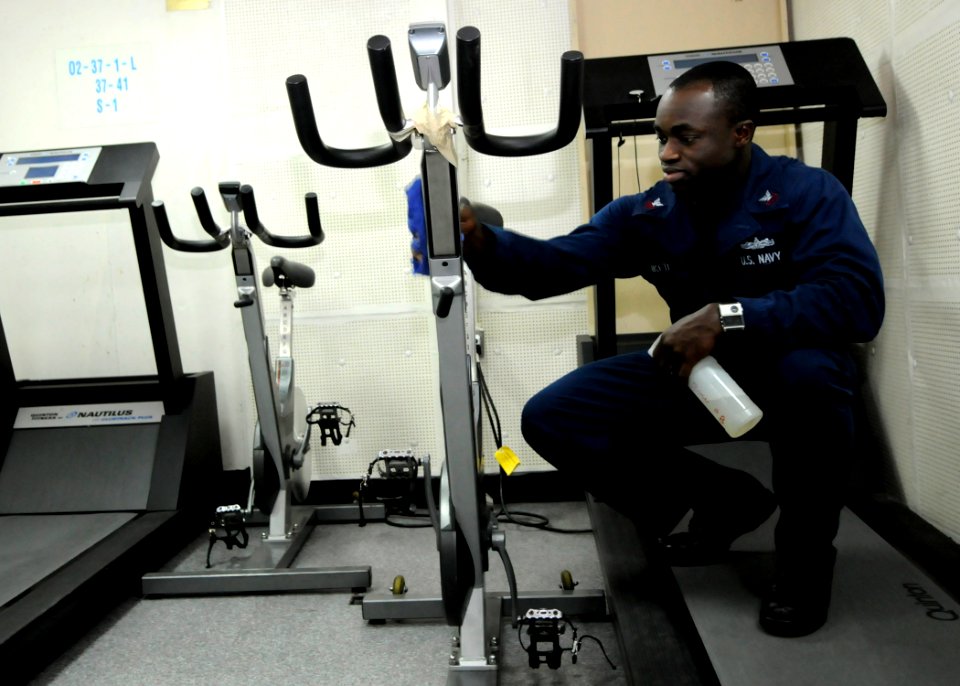 US Navy 110407-N-5716H-006 Navy Career Counselor 1st Class Richard Nketiah cleans the gym during cleaning stations aboard the amphibious transport