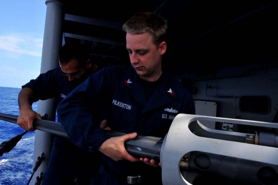 US Navy 110403-N-NL541-005 Gunner's Mate 1st Class Enrique Cruz and Gunner's Mate 1st Class Jeremy Pilkenton remove the barrel from an MK 38 25 mm