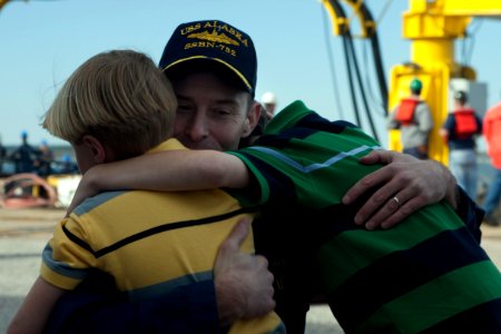US Navy 110405-N-FG395-060 Cmdr. Kevin Byrne hugs two of his sons at the submarine's homecoming at Naval Submarine Base Kings Bay