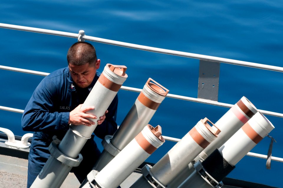 US Navy 110403-N-RC734-030 Cryptologic Technician (Technical) 3rd Class Hermenegildo Salas removes a chaff canister from the launcher aboard the am
