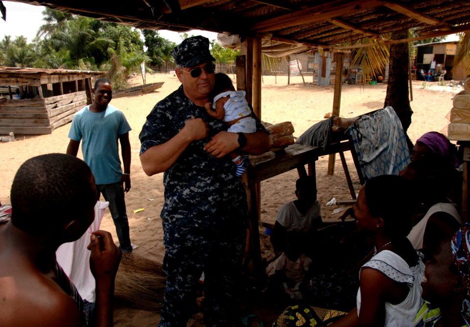 US Navy 110407-N-HI707-825 Capt. Lawrence Rollo cradles a Nigerian baby while visiting with locals during a community relations project at the Ligh