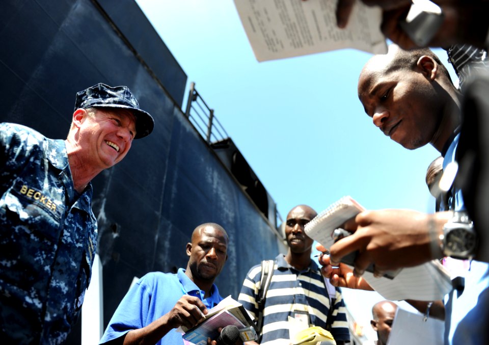 US Navy 110406-N-EC642-034 Cmdr. Mark Becker conducts an interview with Haitian press after offloading 130 metric tons of food delivered aboard Hig