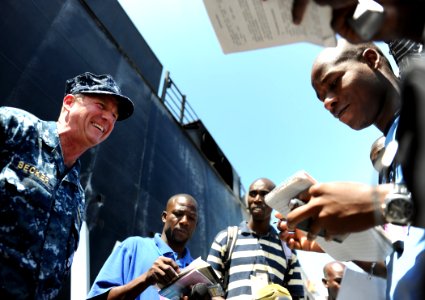 US Navy 110406-N-EC642-034 Cmdr. Mark Becker conducts an interview with Haitian press after offloading 130 metric tons of food delivered aboard Hig photo