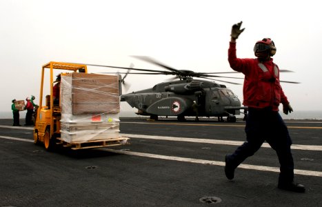 US Navy 110406-N-DR144-360 Sailors unload supplies from an MH-53E Sea Dragon helicopter aboard USS Carl Vinson (CVN 70)