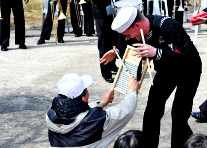US Navy 110406-N-RO948-116 Musician 2nd Class James Caliva interacts with spectators as the U.S. 7th Fleet Band performs at a city park while on to