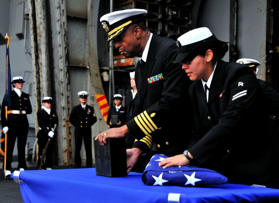 US Navy 110409-N-0074G-026 Sailors aboard USS Enterprise (CVN 65) prepare to cast ashes overboard during a burial at sea