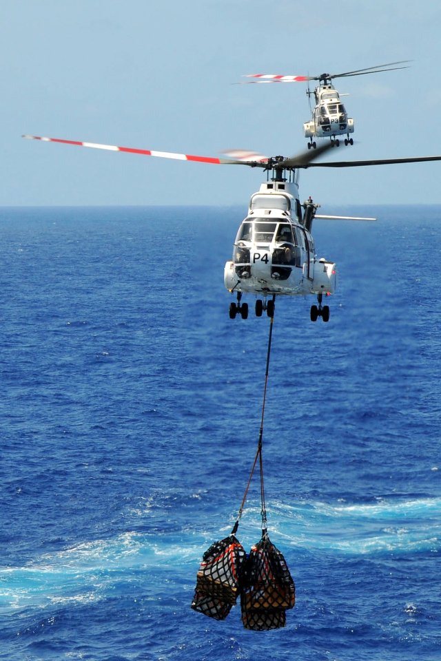 US Navy 110409-N-1004S-632 Two SA-330 Puma helicopter deliver pallets from the Military Sealift Command Lewis and Clark-class dry cargo and ammunit