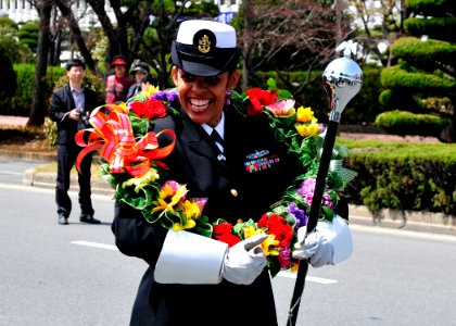 US Navy 110409-N-RO948-012 Chief Musician Lucliada Barbosa tries on a flower wreath as the U.S. 7th Fleet Band prepares to march in a street parade