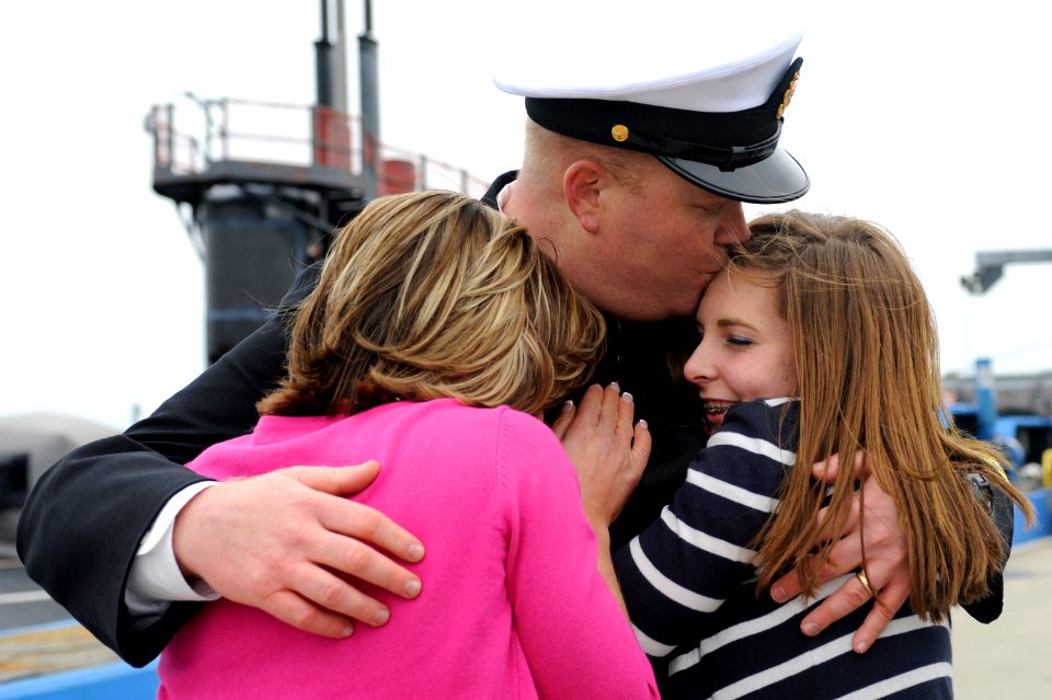 US Navy 110408-N-8467N-006 Senior Chief Sonar Technician (Submarine) Matthew Lindsey hugs his wife and daughter after returning from deployment