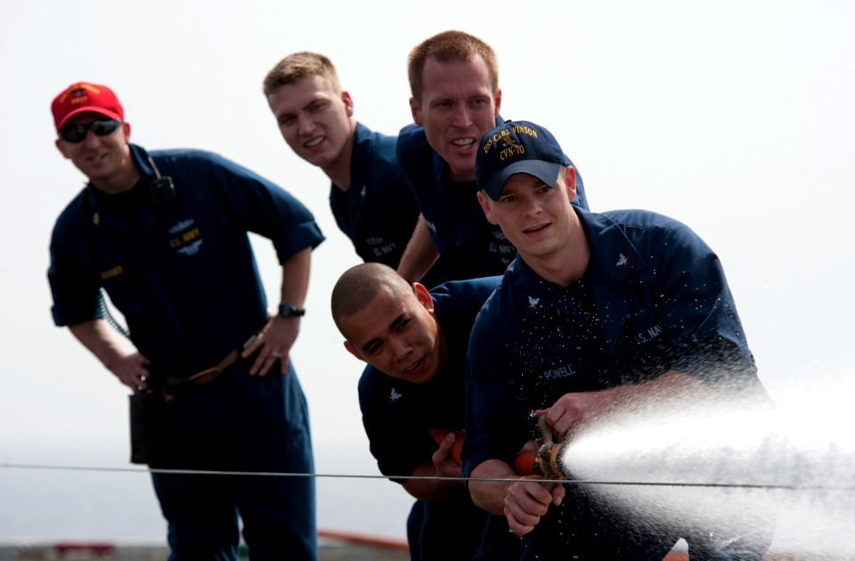 US Navy 110408-N-DR144-090 Hull Maintenance Technician 3rd Class James Powell leads a hose team in a fire hose race during Damage Control Olympics