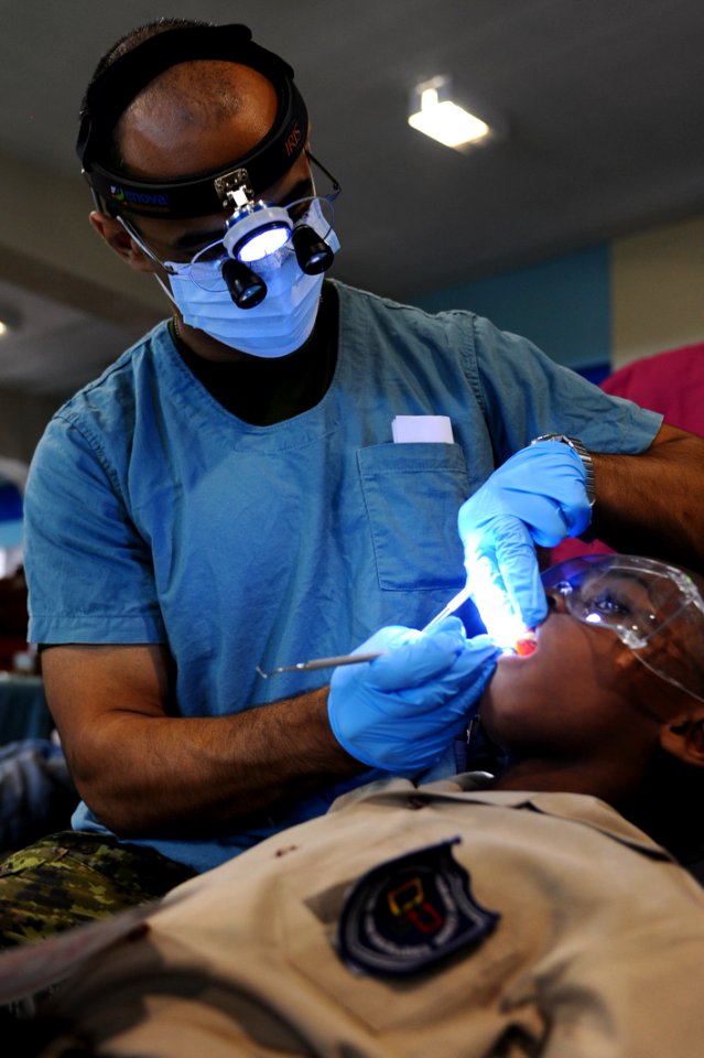 US Navy 110414-F-CF975-077 Canadian Army Capt. Amir Mahmood, from London, Ontario, performs a dental exam on a patient at the medical clinic in the