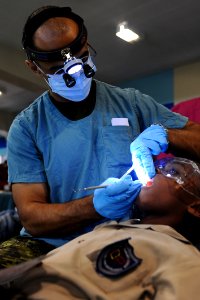 US Navy 110414-F-CF975-077 Canadian Army Capt. Amir Mahmood, from London, Ontario, performs a dental exam on a patient at the medical clinic in the photo