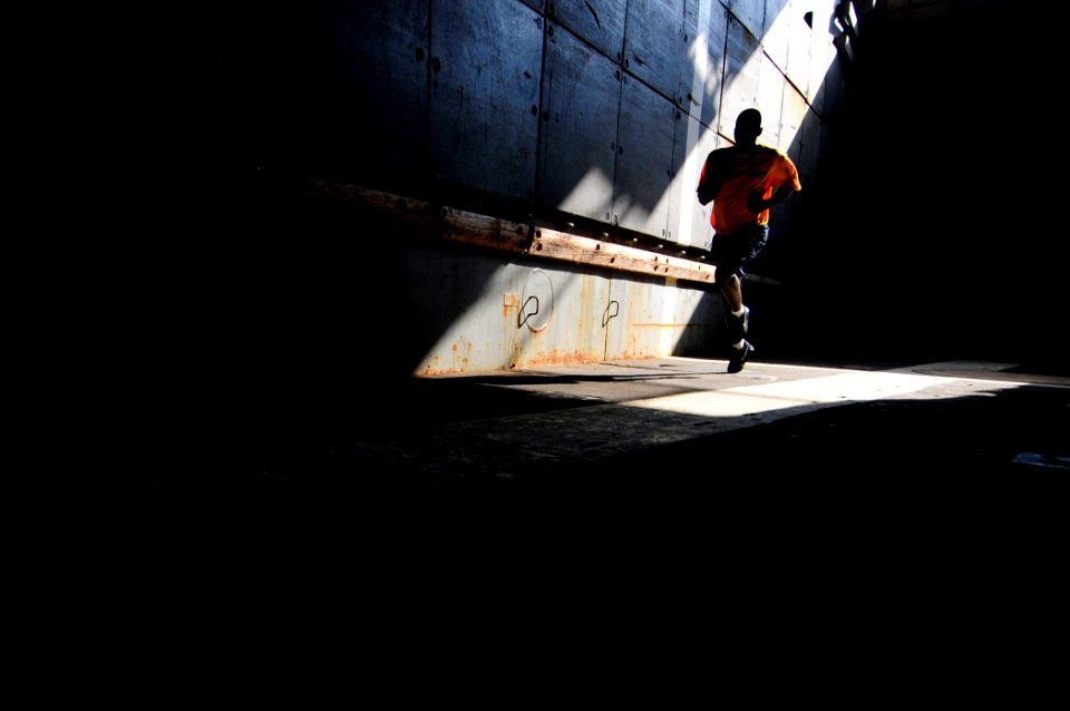 US Navy 110414-N-RC734-618 Ship's Serviceman Seaman Tory Smith runs in the well deck aboard the amphibious dock landing ship USS Comstock (LSD 45)