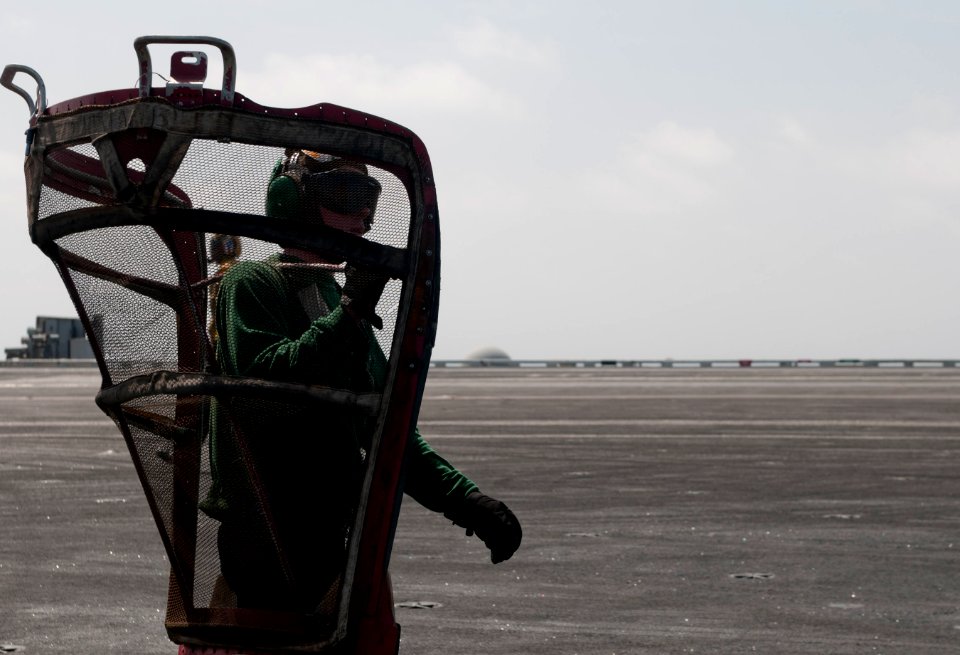 US Navy 110412-N-6505H-205 Aviation Machinist's Mate Airman Joseph Harrison carries an intake screen on the flight deck