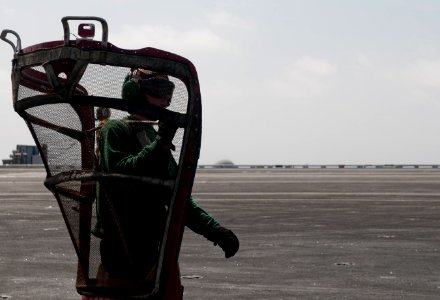 US Navy 110412-N-6505H-205 Aviation Machinist's Mate Airman Joseph Harrison carries an intake screen on the flight deck