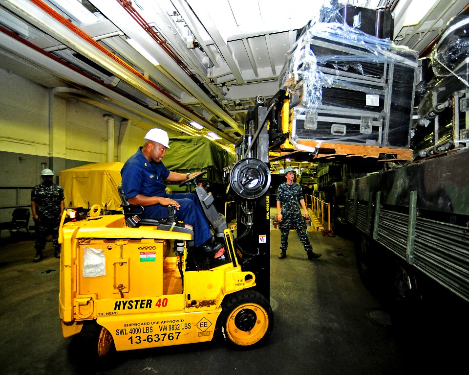 US Navy 110412-F-HS649-025 Chief Boatswain's Mate Tony Young loads equipment onto a truck in the well deck of the amphibious transport dock ship US