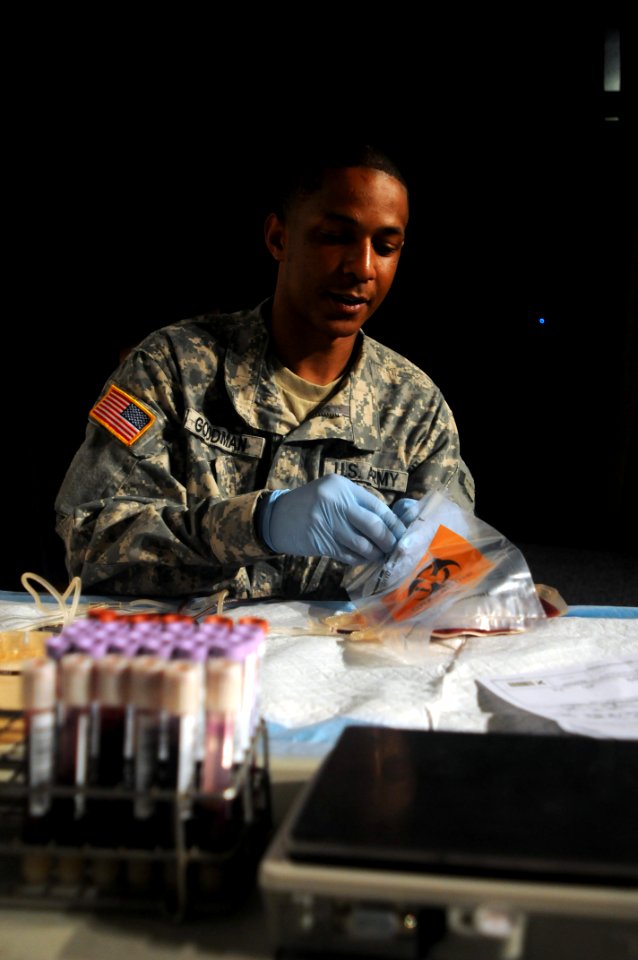 US Navy 110411-N-XD424-084 Army Spc. Christopher Goodman, a lab technician at Tripler Army Medical Center, prepares receptacles for donated blood