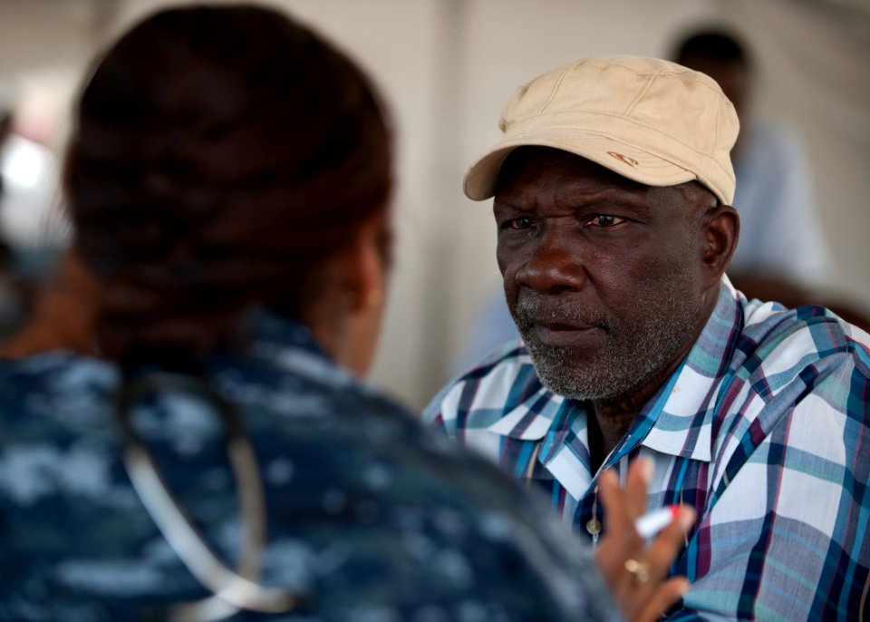 US Navy 110413-N-NY820-211 A Sailor assigned to the Military Sealift Command hospital ship USNS Comfort (T-AH 20) examines a Jamaican man on the fi