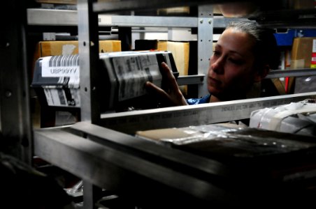 US Navy 110412-N-UO379-155 Logistics Specialist 2nd Class Jillian Yates checks an aircraft part's identification code in an supply storage room abo