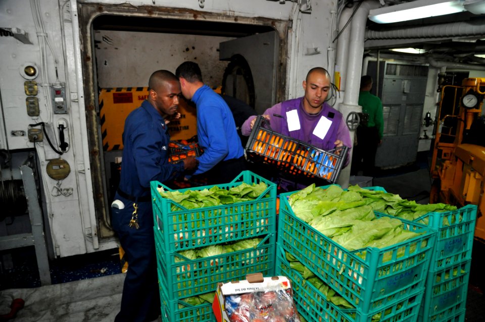 US Navy 110415-N-7293M-288 Aviation Boatswain's Mate (Fuels) 2nd Class Robert Desoto load fresh vegetables onto a cargo elevator for transfer to a
