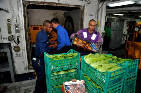 US Navy 110415-N-7293M-288 Aviation Boatswain's Mate (Fuels) 2nd Class Robert Desoto load fresh vegetables onto a cargo elevator for transfer to a
