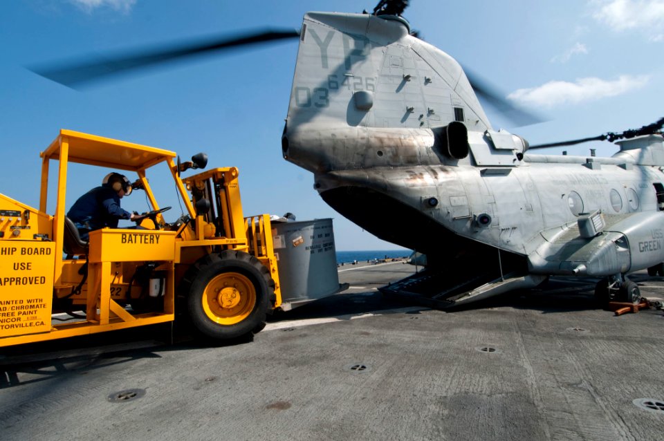 US Navy 110414-N-RC734-043 Boatswain's Mate 3rd Class Zachary Boylston moves cargo with a forklift to load onto a CH-46E Sea Knight helicopter