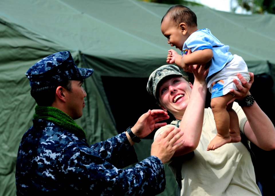 US Navy 110416-F-HS649-183 Army 1st Lt. Elizabeth Brown passes a Tongan baby to Hospital Corpsman 1st Class Andrew Campanano at the Tuanekivale med