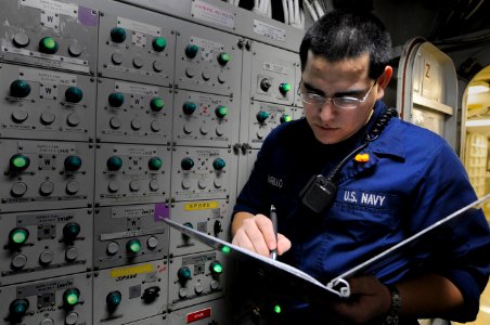 US Navy 110418-N-7488A-058 Electrician's Mate Fireman Juan Jose Murillo enters the status of indicating lights in load center 3 in the load center