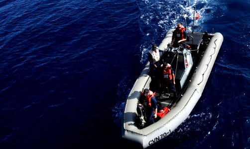 US Navy 110415-N-8040H-025 Sailors stand watch on a rigid-hull inflatable boat prior to a swim call aboard USS Carl Vinson (CVN 70)
