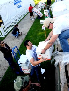 US Navy 110415-N-KK330-088 pecial Warfare Operator 1st Class Quinn Pearson passes a box of books to Special Warfare Boat Operator 1st Class Chad Ca