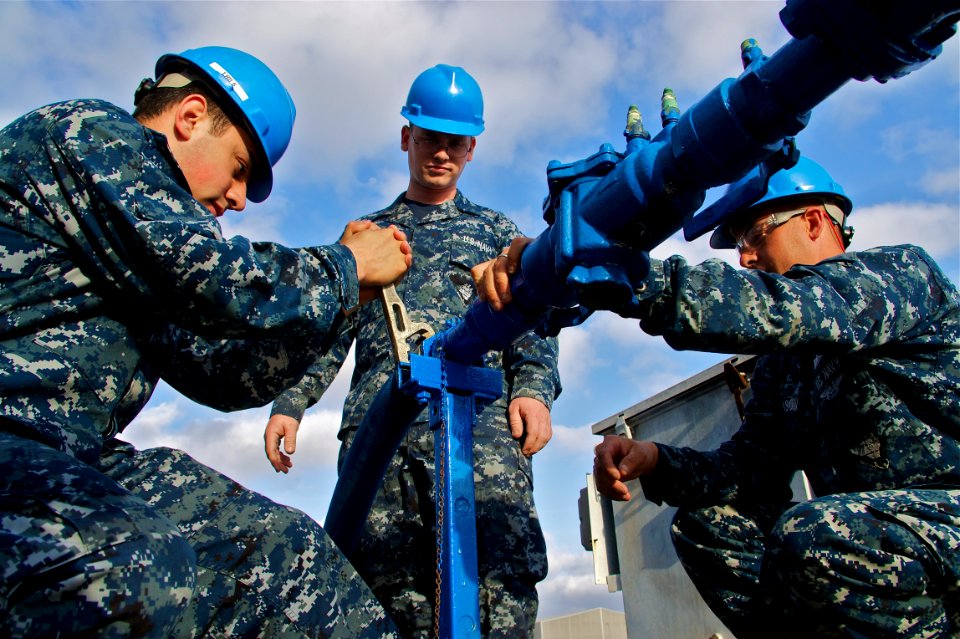 US Navy 110413-N-ZC343-349 Sailors connect potable water to the berthing and messing barge after moving from the NASSCO shipyard to Naval Base San