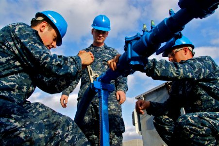 US Navy 110413-N-ZC343-349 Sailors connect potable water to the berthing and messing barge after moving from the NASSCO shipyard to Naval Base San