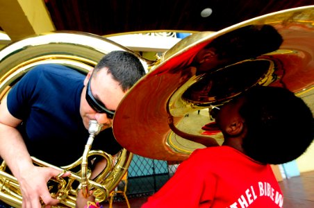 US Navy 110414-N-EP471-311 Musician 3rd Class Christopher Roland, from Oklahoma, plays his tuba for a Jamaican child during a Continuing Promise 20