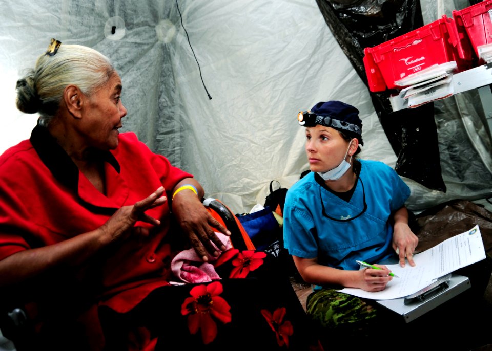 US Navy 110416-F-HS649-090 Canadian dentist Capt. Tiffany Kisway listens to a Tongan woman while writing a referral at the Tuanekivale medical site