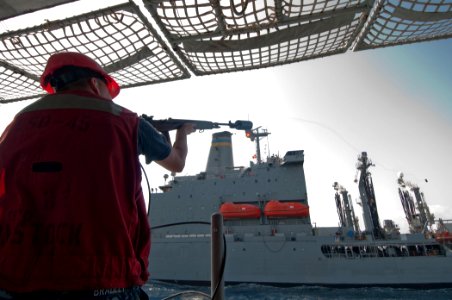 US Navy 110419-N-RC734-067 Gunner's Mate Seaman Curtis Bradley fires a shot-line from the amphibious dock landing ship USS Comstock (LSD 45) to the