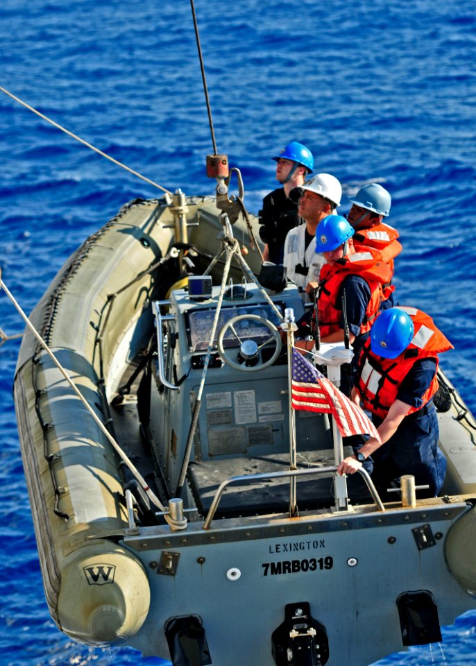 US Navy 110420-N-XO436-060 Sailors assigned to the Arleigh Burke-class guided-missile destroyer USS Barry (DDG 52) are hoisted back onto the ship a