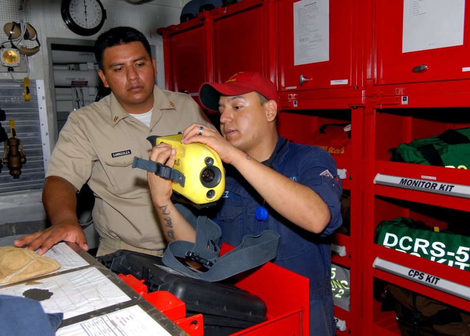 US Navy 110419-N-ZI300-116 Hull Technician Fireman Edward Lopez explains firefighting equipment and techniques to Mexican navy Lt. Roman Alfonso Sa