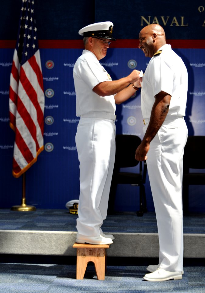 US Navy 110422-N-5328N-863 Center for Information Dominance Corry Station Command Master Chief Christopher Thompson stands on a stool to pin chief