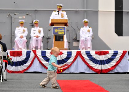 US Navy 110421-N-DX615-011 A boy plays in the aisle as Vice Adm. Gerald R. Beaman, incoming commander of U.S. 3rd Fleet, speaks during the U.S. 3rd