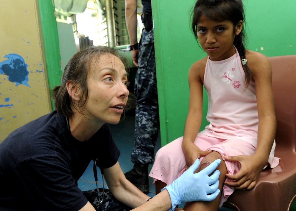 US Navy 110419-N-YM863-178 Lt. Cmdr. Rivka Weiss diagnoses an infection on a child's knee during a Pacific Partnership 2011 medical community servi