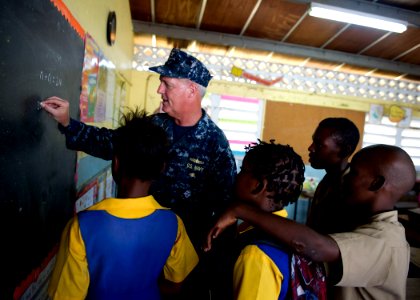 US Navy 110419-N-RM525-227 Capt. Michael Jacobsen, U.S. 4th Fleet chief of staff, plays math games with school children during a Continuing Promise photo