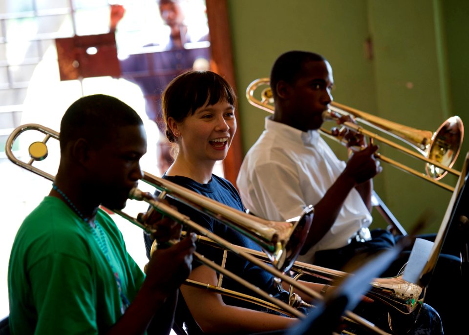 US Navy 110420-N-RM525-033 Musician 3rd Class Loralee Swanson, from Rapid City, S.D., listens as trombone players from the Alpha Boys School concer