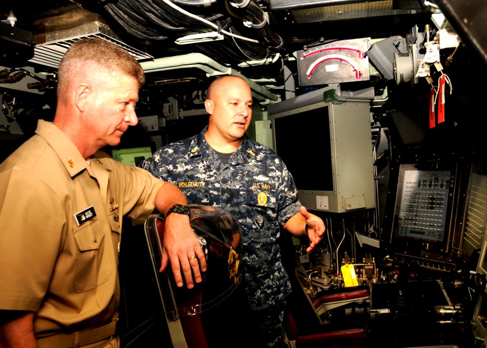 US Navy 110418-N-UK333-022 Master Chief Sonar Technician (Submarine) Rory Wohlgemuth explains the controls and operations of the boat to Master Chi