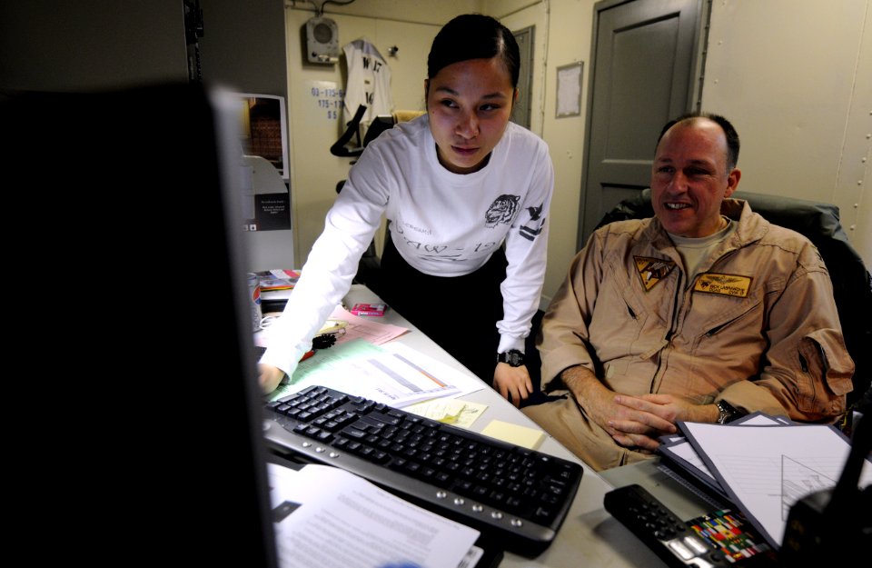 US Navy 110419-N-8040H-077 Information Systems Technician 2nd Class An-Marie Ledesma verifies system operations for Capt. Rick LaBranche, deputy co