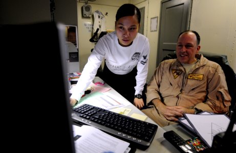US Navy 110419-N-8040H-077 Information Systems Technician 2nd Class An-Marie Ledesma verifies system operations for Capt. Rick LaBranche, deputy co