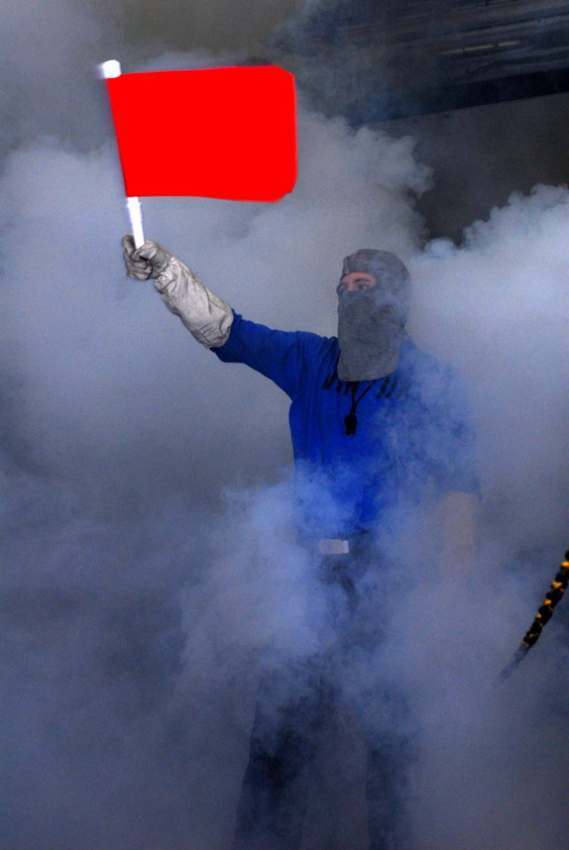 US Navy 110423-N-SB672-003 Aviation Boatswain's Mate (Handling) Airman Justin Martin waves a flag signifying a fire during a mass casualty drill