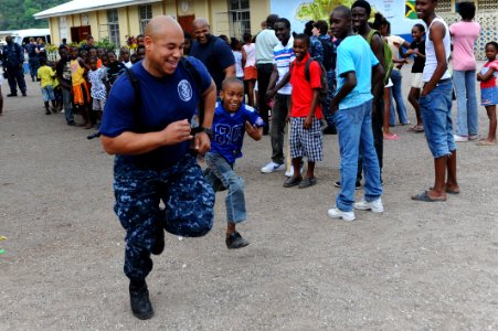 US Navy 110421-F-CF975-025 Hospital Corpsman 2nd Class Jasmin Copeland, from Chesapeake, Va., races a primary school student during a Continuing Pr photo