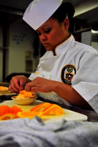 US Navy 110419-N-ZS026-038 Culinary Specialist 3rd Class Shayne Lopez decorates a cake aboard the amphibious assault ship USS Boxer (LHD 4)