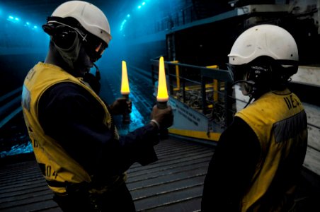US Navy 110422-N-GW695-027 Boatswain's Mate 1st Class Marvin Tapper, left, instructs Boatswain's Mate Seaman Apprentice Rocio Carranza, on how to p