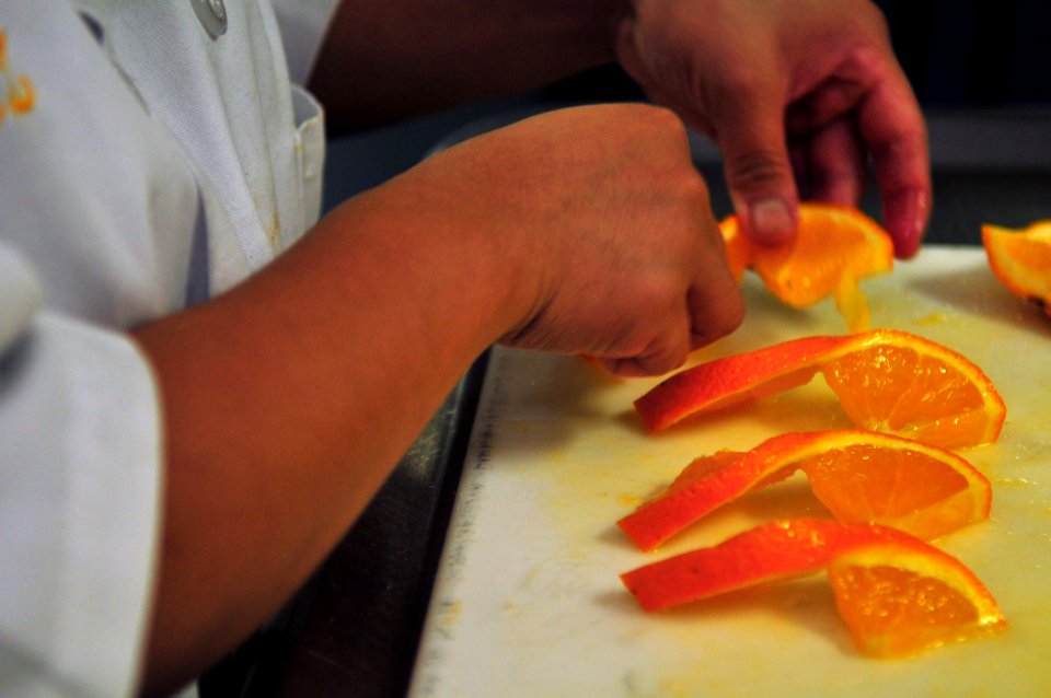 US Navy 110419-N-ZS026-034 Culinary Specialist 3rd Class Shayne Lopez prepares orange slices aboard the amphibious assault ship USS Boxer (LHD 4)